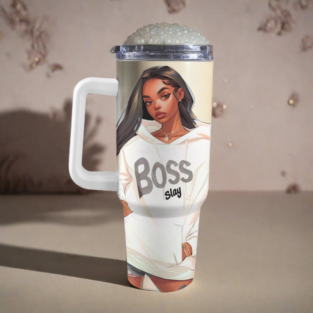 Travel mug with a handle, featuring an illustrated design of a woman wearing a hoodie with the text "boss slay" on a sandy textured background.