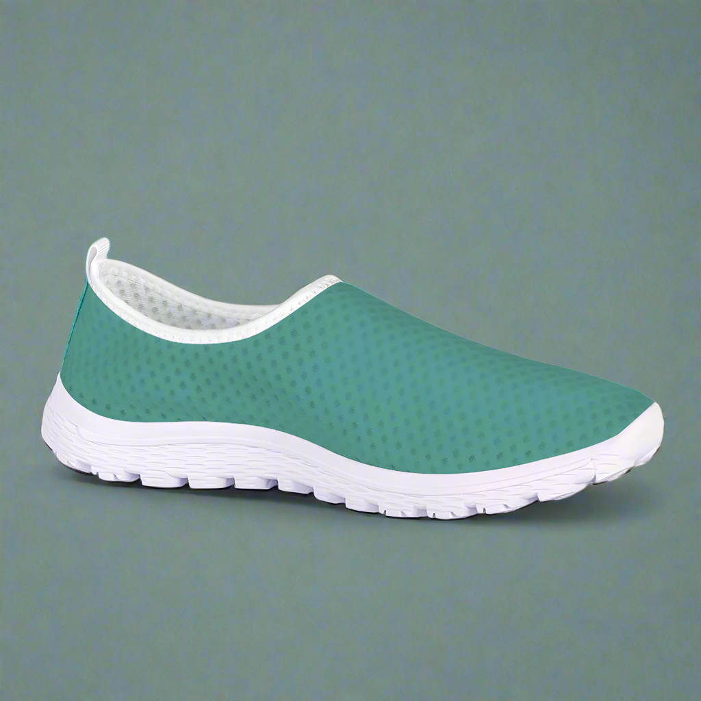 The Next Level Cushion Kicks, featuring a teal slip-on design with a textured mesh upper and white sole, are stylishly showcased against a pristine white background.