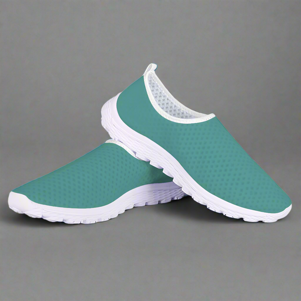 The Next Level Cushion Kicks, featuring a teal slip-on design with a textured mesh upper and white sole, are stylishly showcased against a pristine white background.