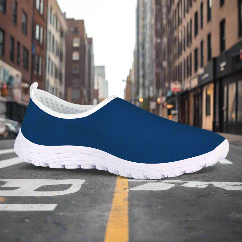 A side view of the Denim Blue Kushion Kicks showcases its white sole and mesh fabric upper against a plain white background.