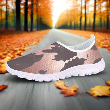 The Fall Flow Cushion Kicks are slip-on athletic shoes with a white sole and a camouflage pattern in pink, brown, and gray tones, featuring breathable mesh for maximum comfort.