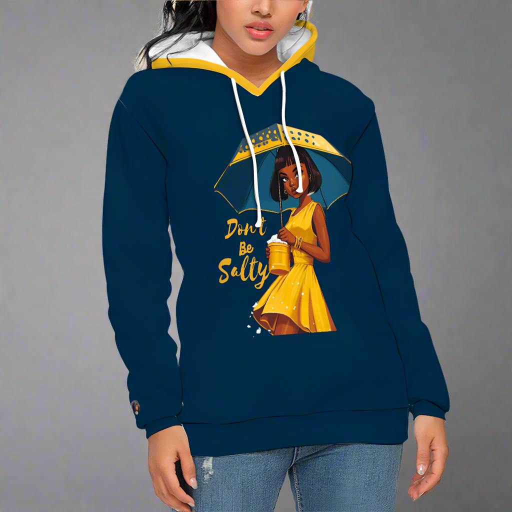 This navy and yellow pullover sweatshirt from the "Don't Be Salty" collection features a vibrant thermal transfer print of a person in a yellow dress with an umbrella, accompanied by the playful text "Don't Be Salty.